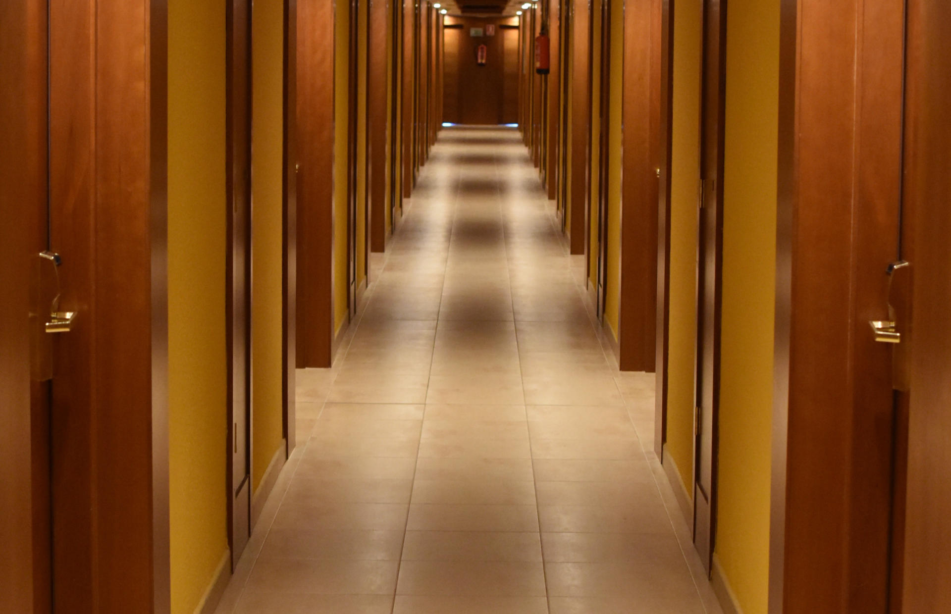 A hotel hallway is lined with rooms on either side.