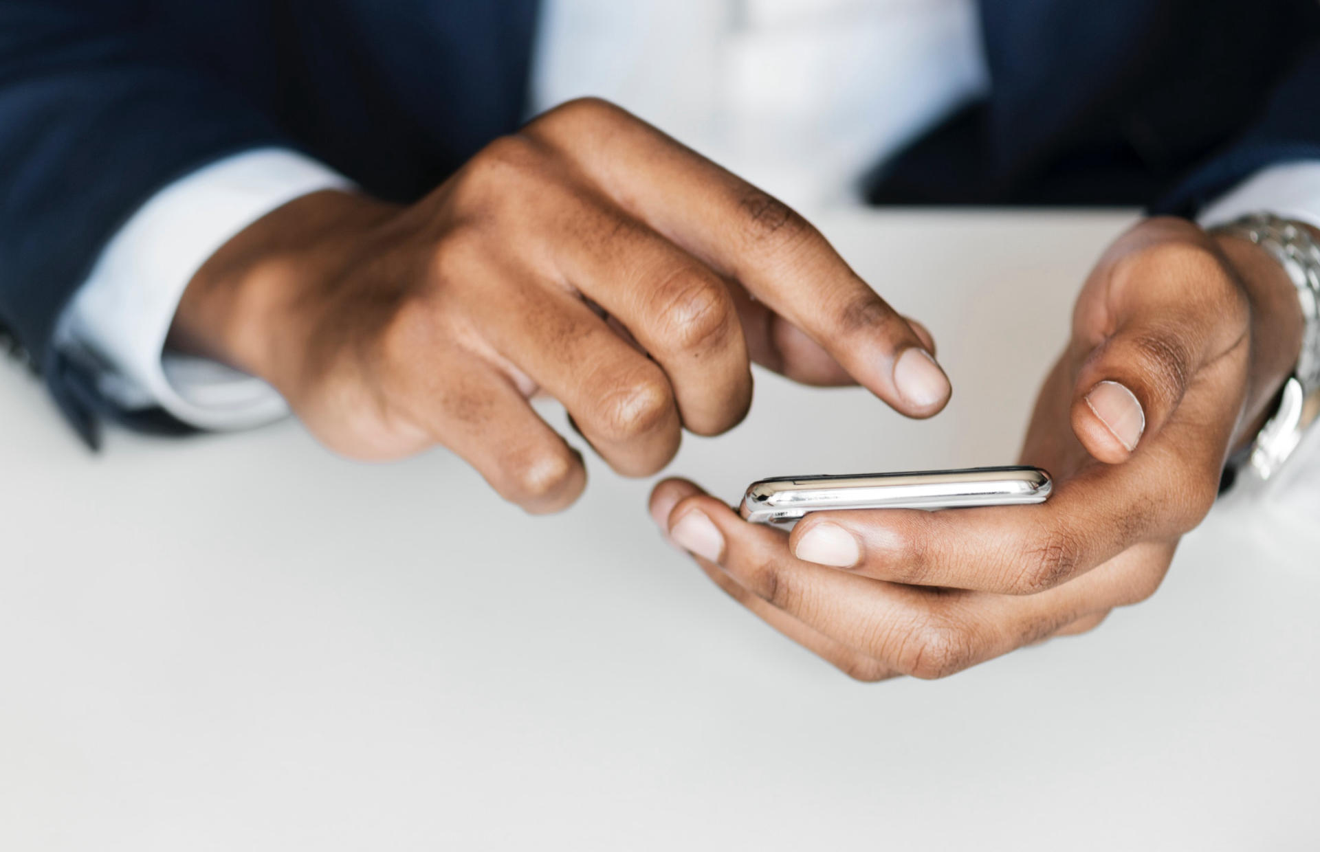 A business person holds their phone in one hand.