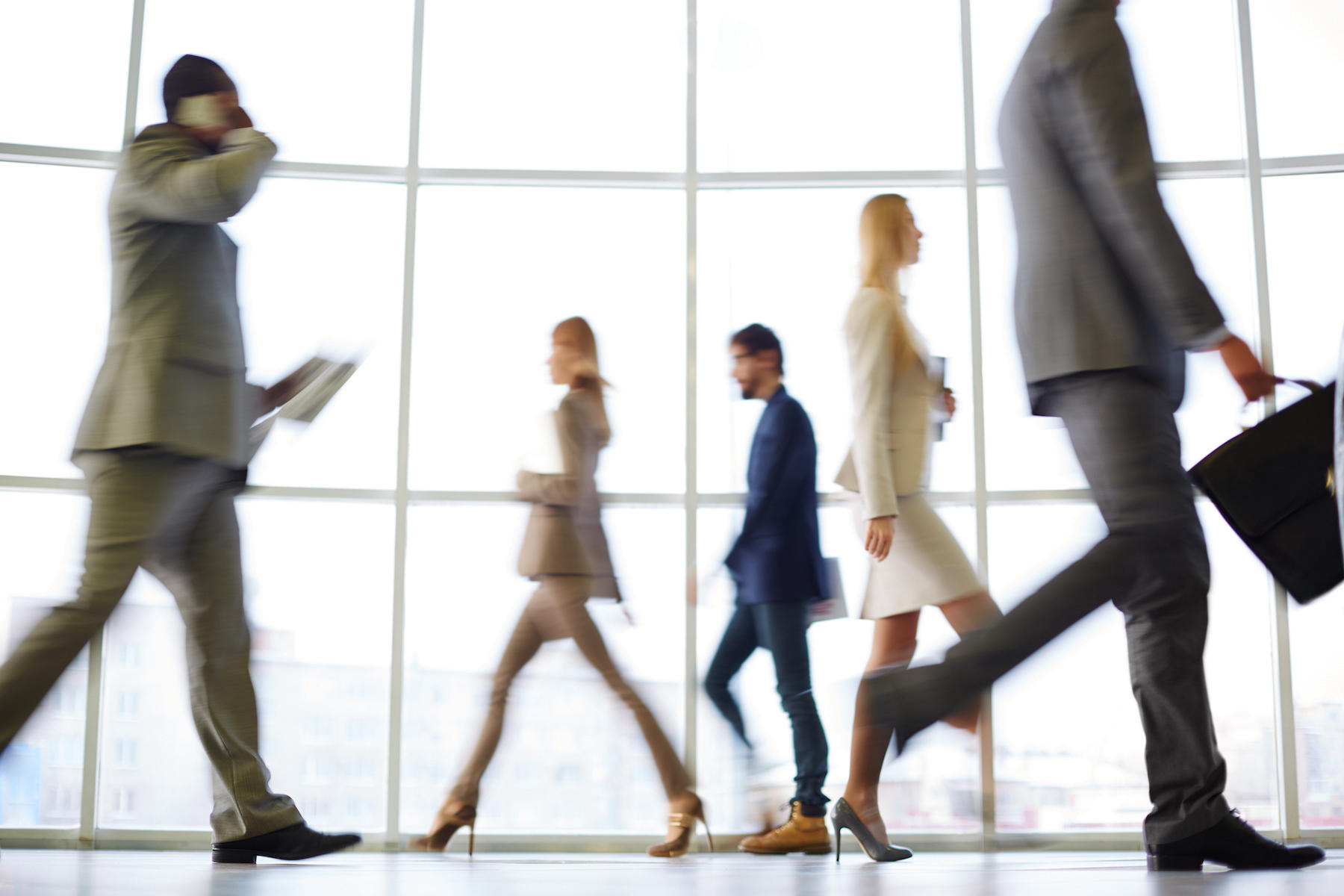 Business people walk past each other.