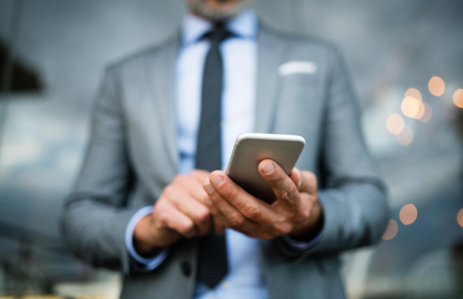 A business person looks down at their phone.