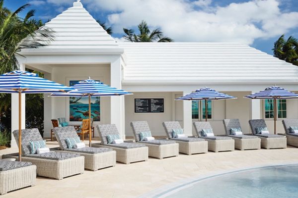 Lounge chairs and umbrellas by the pool at an EOS Hospitality property