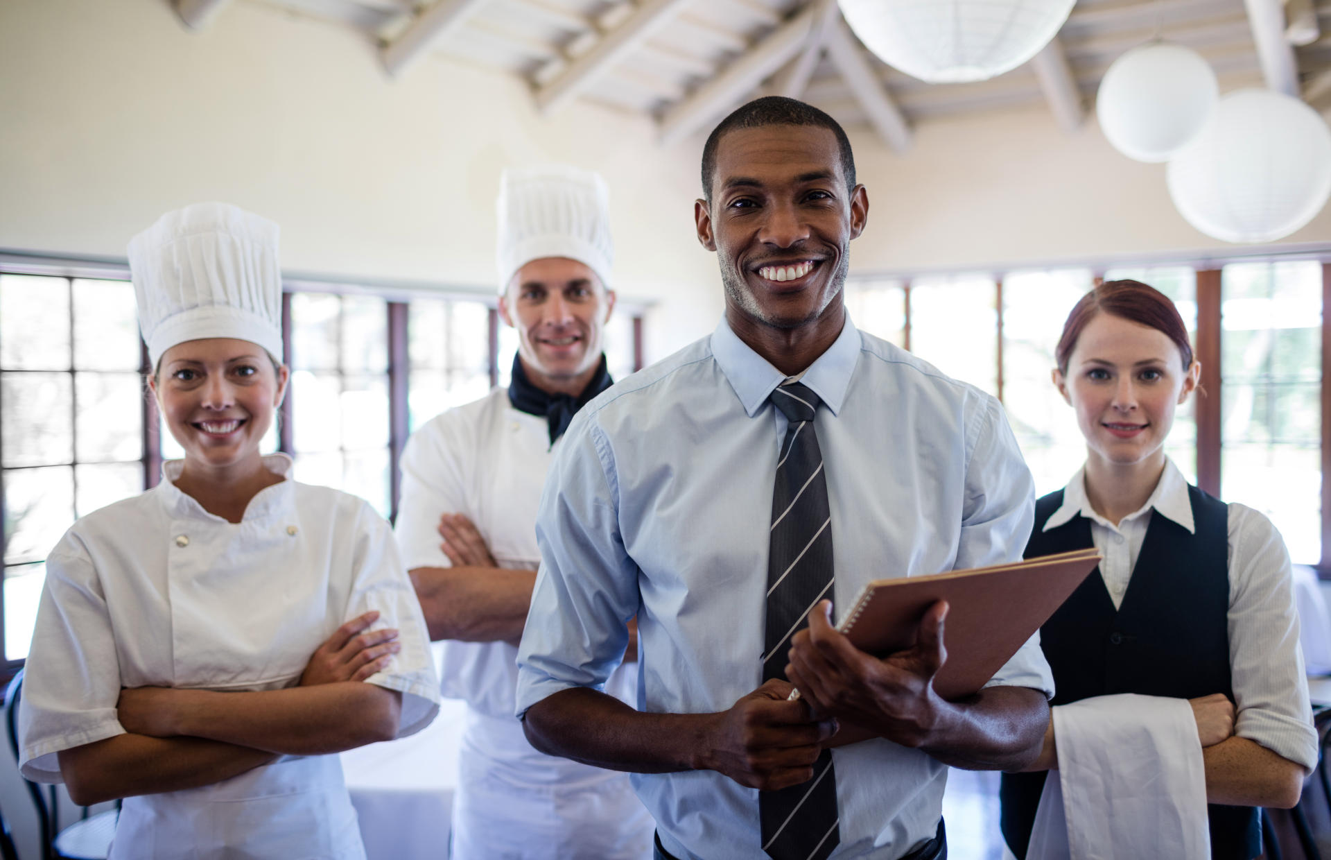 A group of hotel staff members stands and smiles.