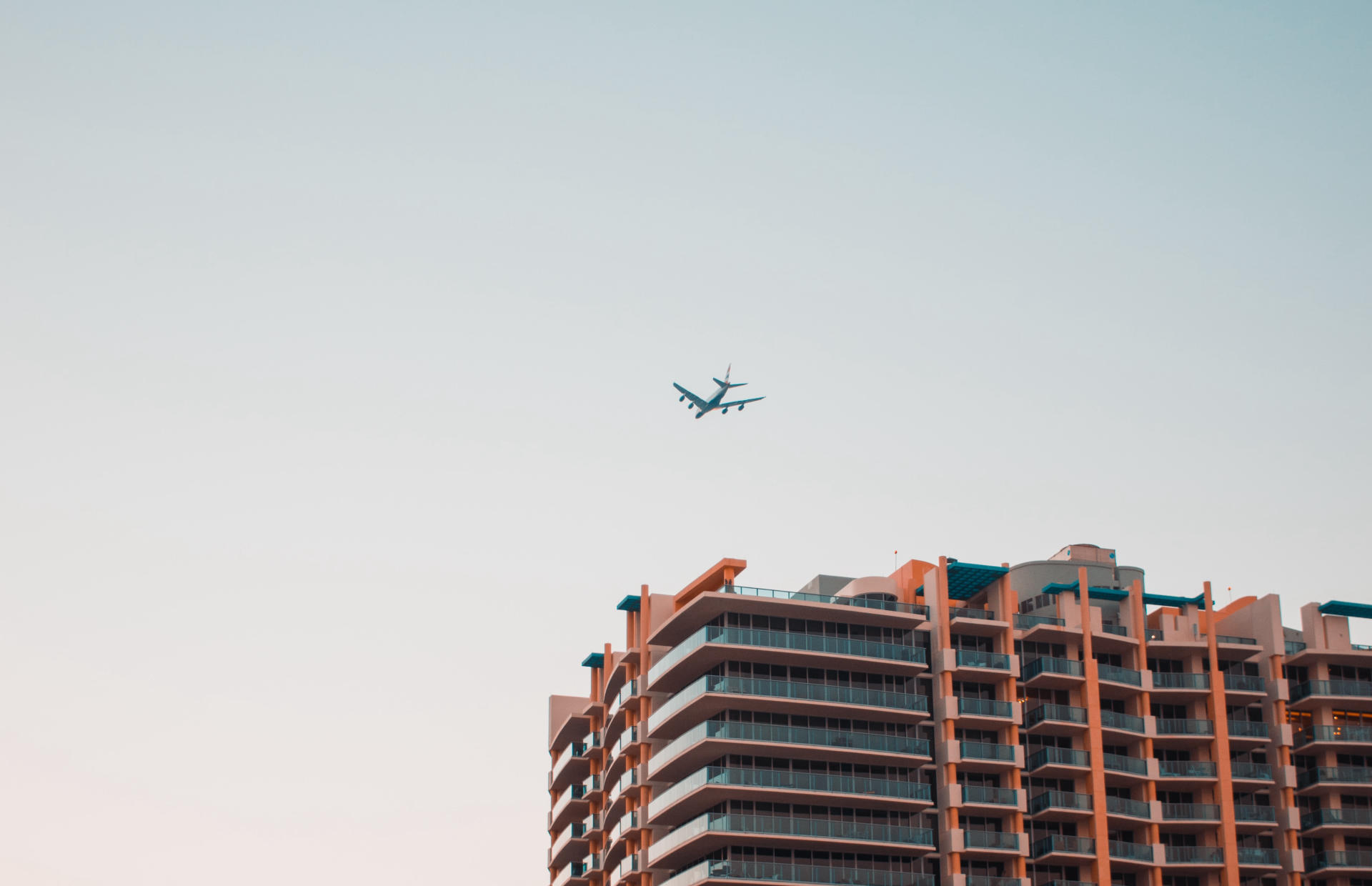 A plane flies over a hotel.