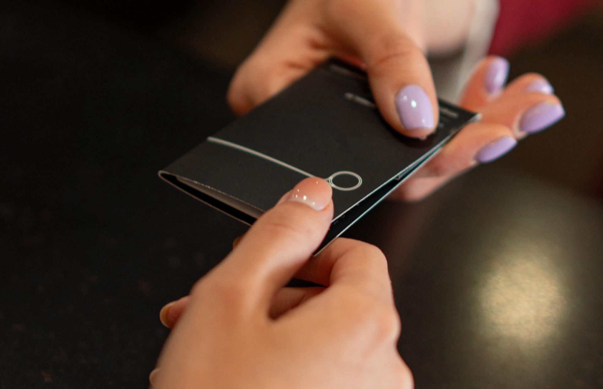 A hotel staff member hands a guest a key card.