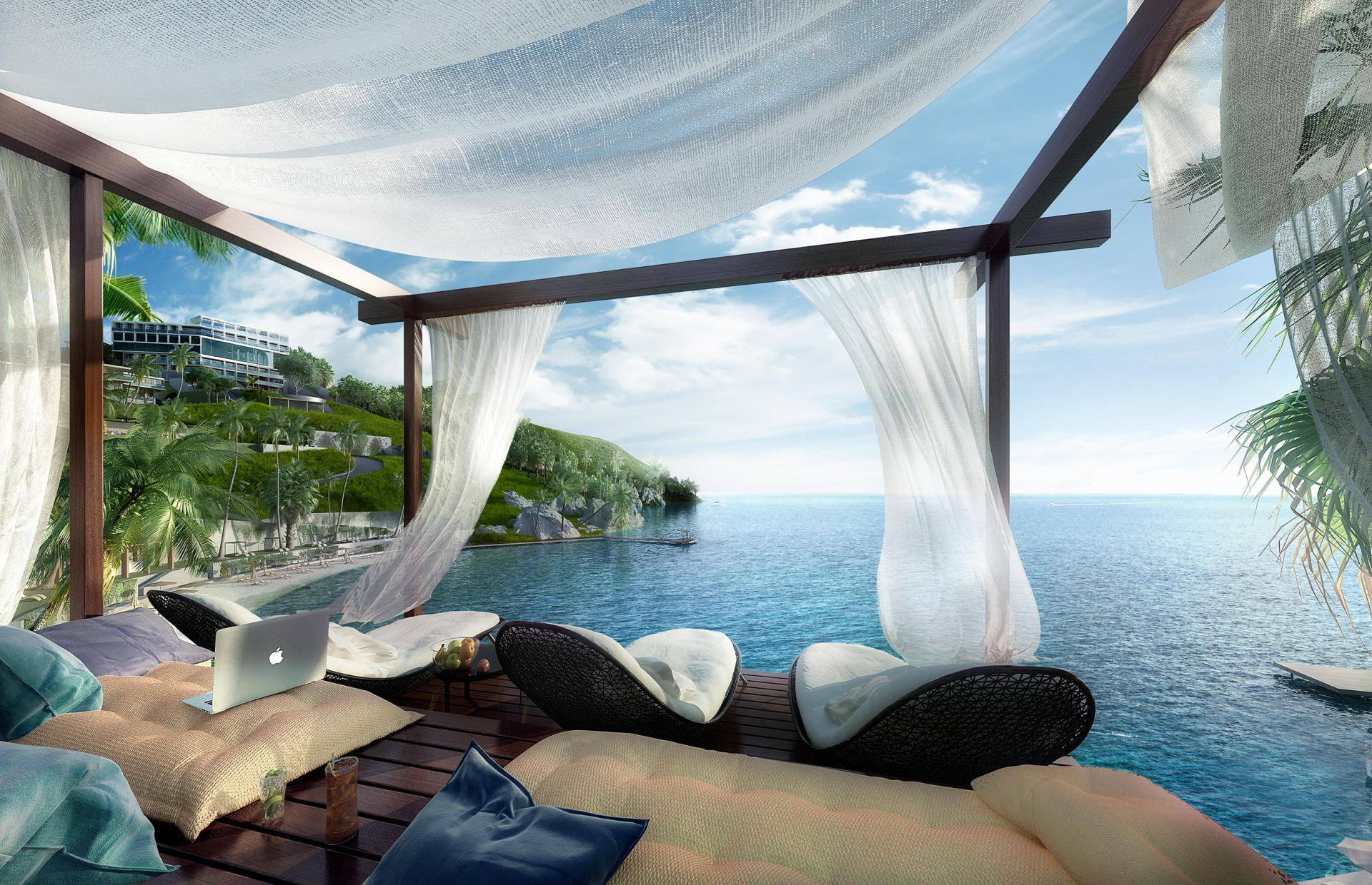 A cabana with white curtains overlooks the ocean.