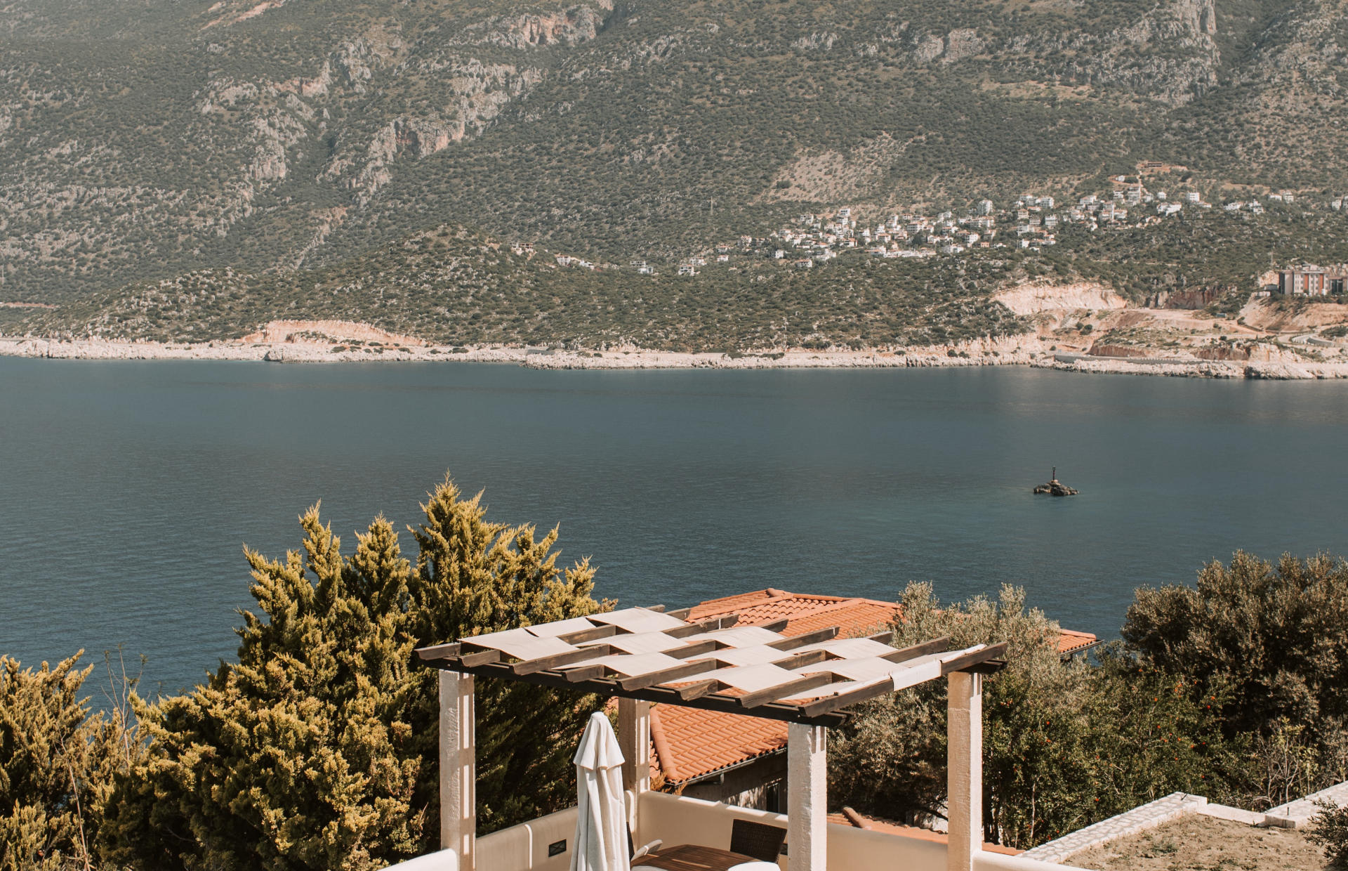 A hotel veranda overlooks a body of water.