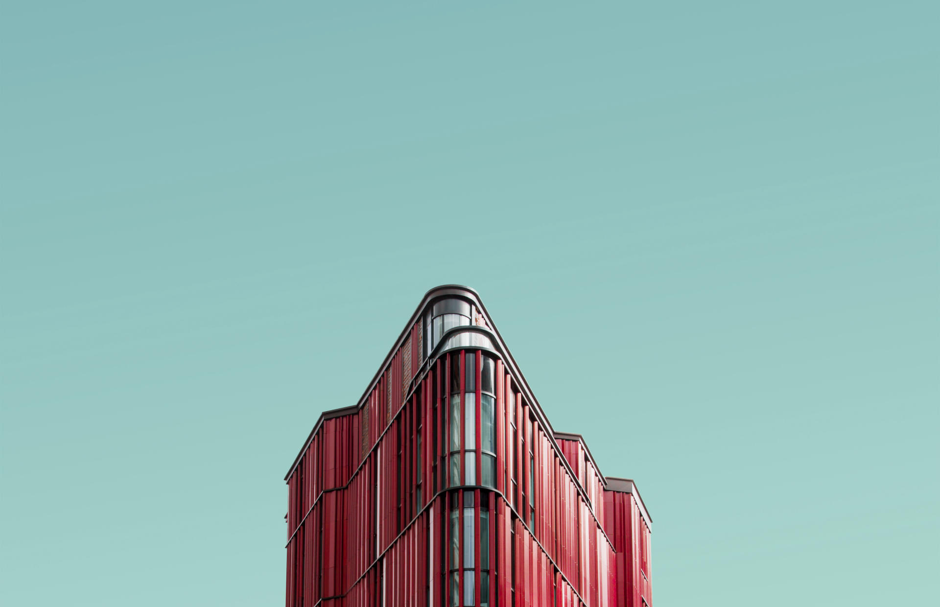 A pink hotel is positioned against a blue sky.