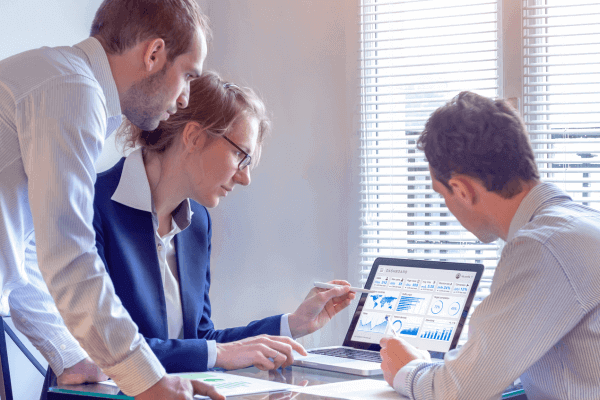 Staffing gathering around a laptop to analyze call reports.